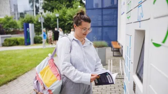Customer Experience Management | Uniwersytet WSB Merito we Wrocławiu: studentka odbierająca książkę z książkomatu