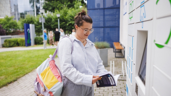 Customer experience management | Uniwersytet WSB Merito we Wrocławiu: studentka odbierająca książkę z książkomatu