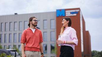 Event Manager | Uniwersytet WSB Merito we Wrocławiu: studenci rozmawiający ze sobą przed budynkiem uczelni