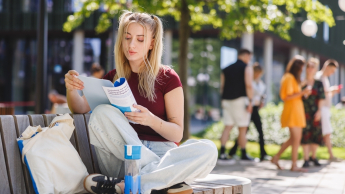 Psychoneuroimmunologia (PNI) | Studia podyplomowe we Wrocławiu | Uniwersytet WSB Merito we Wrocławiu: studentka czytająca informator na ławce w parku