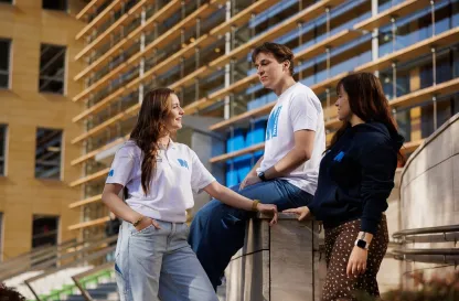 studenci rozmawiający ze sobą przed budynkiem uczelni