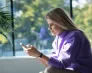 Prezentacja podróżnicza „Rowerem po Ameryce Południowej” | Aktualności | Uniwersytet WSB Merito we Wrocławiu: Dziewczyna patrząca na smartfon