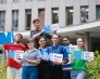 Grupa studentów stoi przed budynkiem