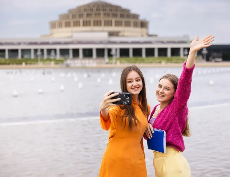 Turystyka i rekreacja – studia 3-semestralne | Studia II stopnia we Wrocławiu | Uniwersytet WSB Merito we Wrocławiu: studencki robiące sobie wspólne zdjęcie przez Halą Stulecia we Wrocławiu