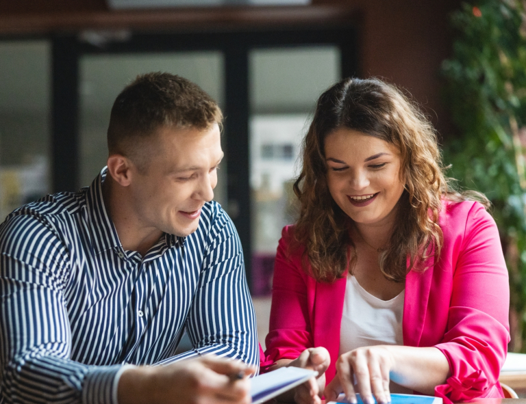 Cyberbezpieczeństwo | Studia I stopnia we Wrocławiu | Uniwersytet WSB Merito we Wrocławiu: student i studentka pracujący nad projektem w kawiarni