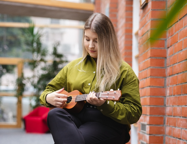 Produkcja muzyczna | Studia podyplomowe we Wrocławiu | Uniwersytet WSB Merito we Wrocławiu: uczestniczka studiów podyplomowych grająca na ukulele