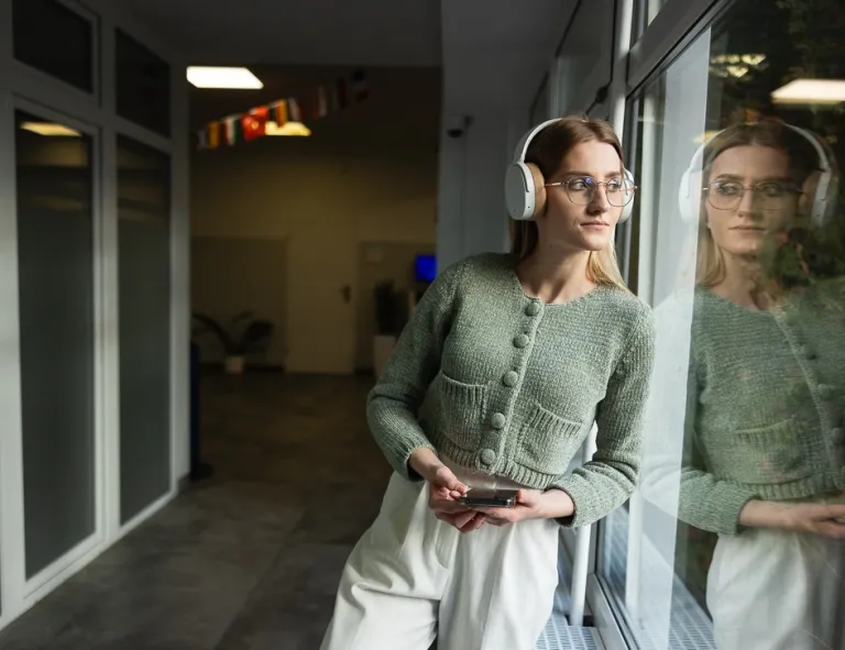 Trendy & design w marketingu | Studia II stopnia ze studiami podyplomowymi  | Uniwersytet WSB Merito we Wrocławiu: studentka słuchająca muzyki w słuchawkach