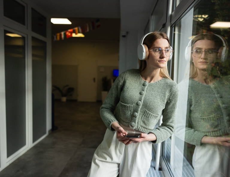 Trendy & design w marketingu | Studia I stopnia we Wrocławiu | Uniwersytet WSB Merito we Wrocławiu: studentka słuchająca muzyki w słuchawkach