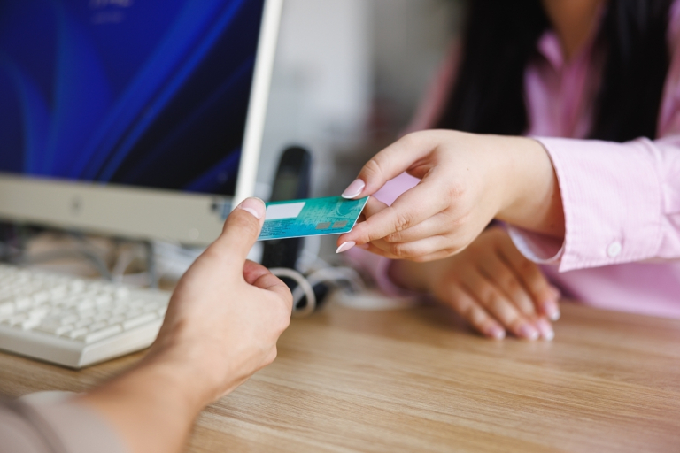 Dziekanat | Uniwersytet WSB Merito we Wrocławiu: studentka w dziekanacie przekazująca legitymację do podbicia