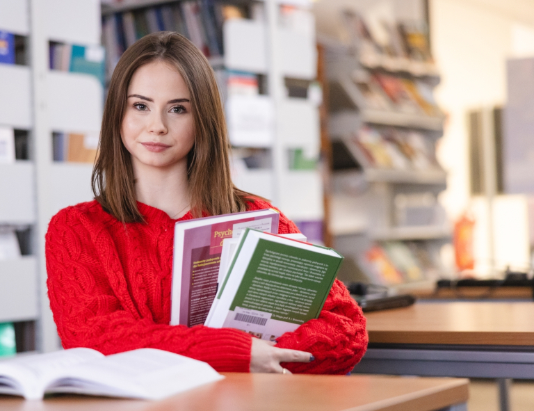 Filologia angielska | Studia II stopnia we Wrocławiu | Uniwersytet WSB Merito we Wrocławiu: studentka w bibliotece trzymająca książki