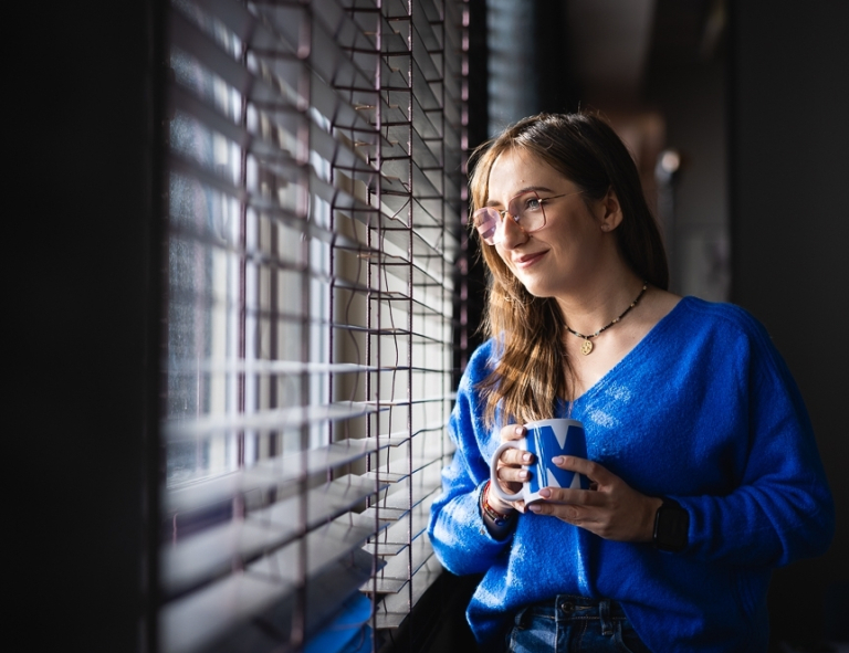 Język niemiecki w przedsiębiorstwie | Studia podyplomowe we Wrocławiu | Uniwersytet WSB Merito we Wrocławiu: uczestniczka studiów podyplomowych patrząca przez okno