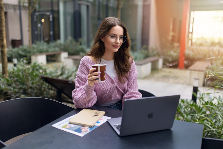 Sztuczna inteligencja w automatyzacji biznesu, studia podyplomowe: uczestniczka studiów podyplomowych pijąca kawę i pracująca na laptopie