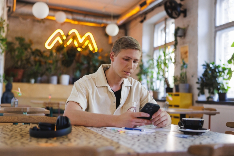 Zarządzanie zmianą w transformacjach | Studia podyplomowe we Wrocławiu | Uniwersytet WSB Merito we Wrocławiu: student patrzący w telefon