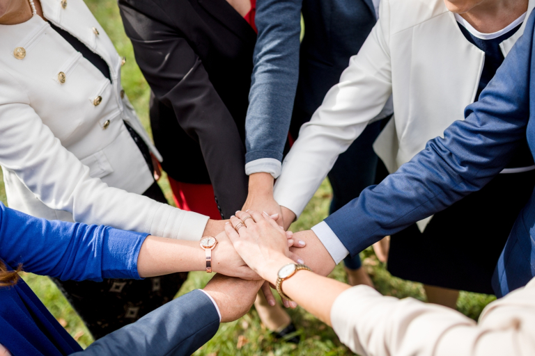 Oferta dla biznesu | Uniwersytet WSB Merito we Wrocławiu: pracownicy uczelni układający dłonie w geście współpracy