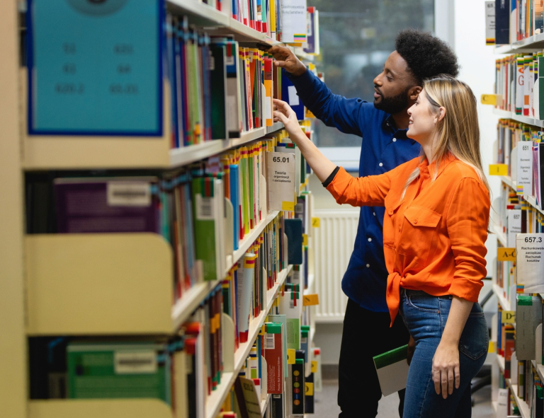 Biznes międzynarodowy | Studia I stopnia we Wrocławiu | Uniwersytet WSB Merito we Wrocławiu: studenci przeglądający książki w bibliotece