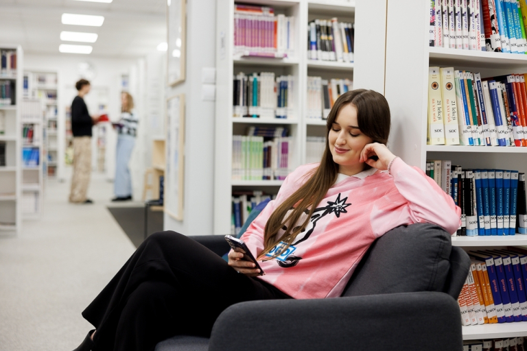 Biblioteka | Uniwersytet WSB Merito we Wrocławiu: studentka siedząca w bibliotece