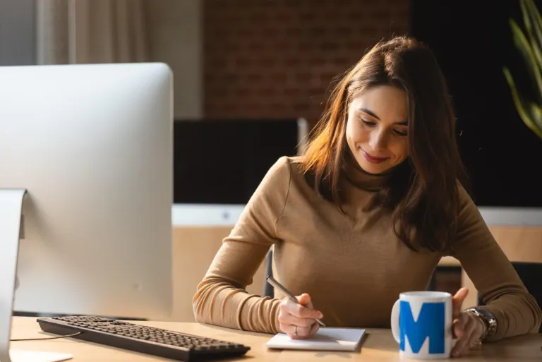 Zarządzanie spedycją | Uniwersytet WSB Merito we Wrocławiu: kobieta pracująca przy komputerze z kubkiem kawy