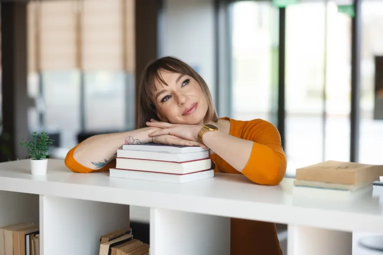 Rachunkowość i podatki | Uniwersytet WSB Merito we Wrocławiu: studentka opierająca się o stertę książek