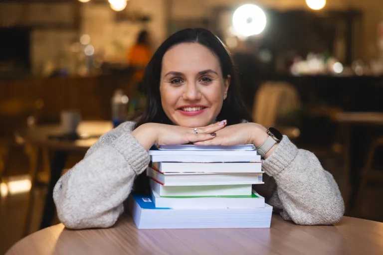 Pedagogika | Studia I stopnia we Wrocławiu | Uniwersytet WSB Merito we Wrocławiu: studentka opierająca się o stertę książek