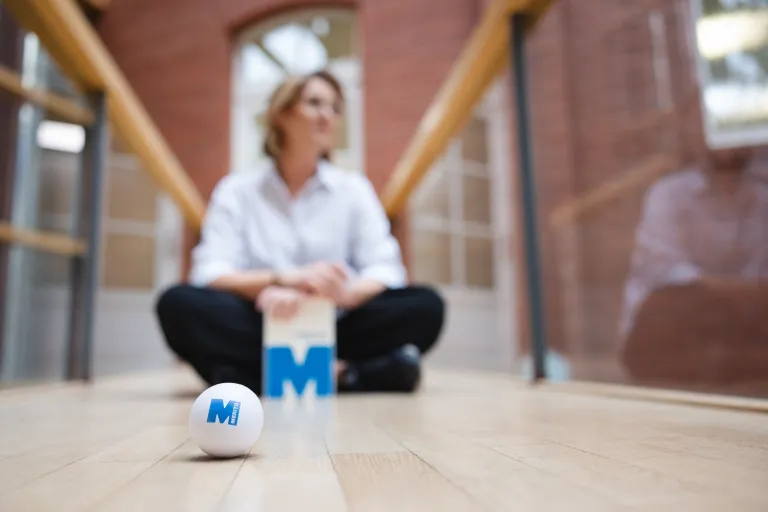 Tłumaczenia | Uniwersytet WSB Merito we Wrocławiu: studentka siedząca na podłodze z notesem w ręcę