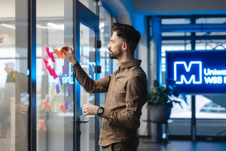 Architekt systemów psychotechnologicznych | Uniwersytet WSB Merito we Wrocławiu: student przyklejający fiszki do szyby