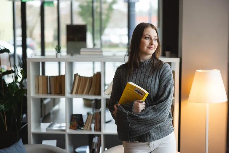 Komunikacja biznesowa i PR | Studia I stopnia we Wrocławiu | Uniwersytet WSB Merito we Wrocławiu: studentka trzymająca książkę
