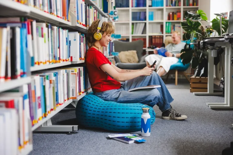 Dietetyka kliniczna i dietoterapia chorób niezakaźnych | Studia I stopnia we Wrocławiu | Uniwersytet WSB Merito we Wrocławiu: studentka słuchająca muzyki w bibliotece