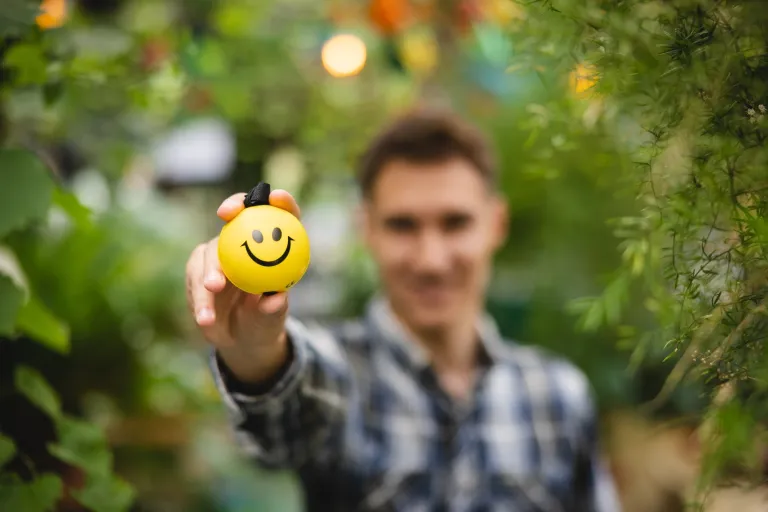 E-marketing z elementami AI | Uniwersytet WSB Merito we Wrocławiu: student trzymający piłeczkę z uśmiechem