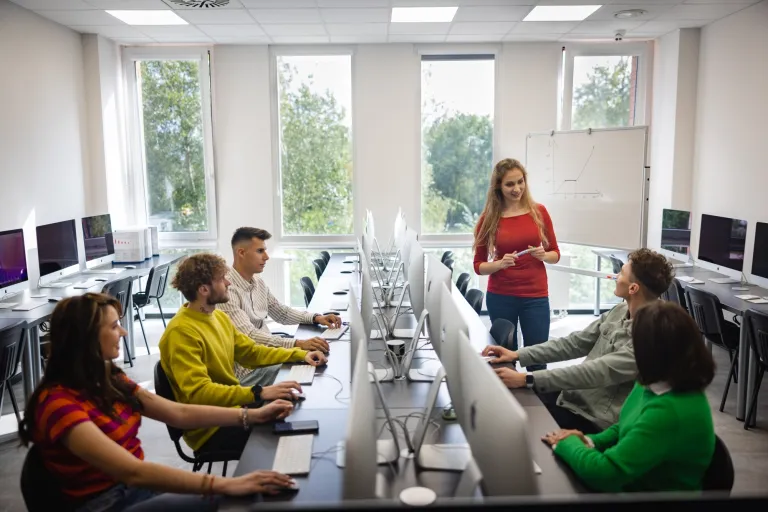 Dyplomacja i protokół dyplomatyczny | Uniwersytet WSB Merito we Wrocławiu: studenci podczas zajęć w pracowni komputerowej apple imac