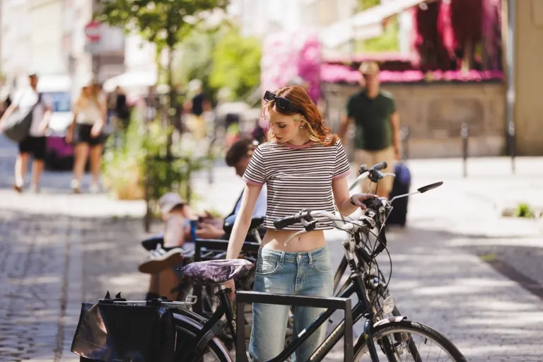 Rowerem na uczelnię? W drogę! | Aktualności | Uniwersytet WSB Merito we Wrocławiu: studentka parkująca rower