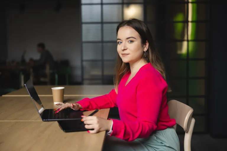 Menedżer logistyki – studia 3-semestralne | Studia I stopnia we Wrocławiu | Uniwersytet WSB Merito we Wrocławiu: Dziewczyna siedzi przy stole z laptopem i tabletem