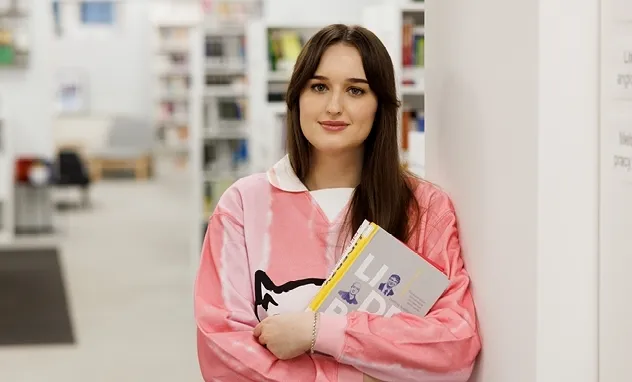 Masz pracę dyplomową? Wykorzystaj ją! Zdobądź uznanie i atrakcyjne nagrody | Aktualności | Uniwersytet WSB Merito we Wrocławiu: Studentka z książką